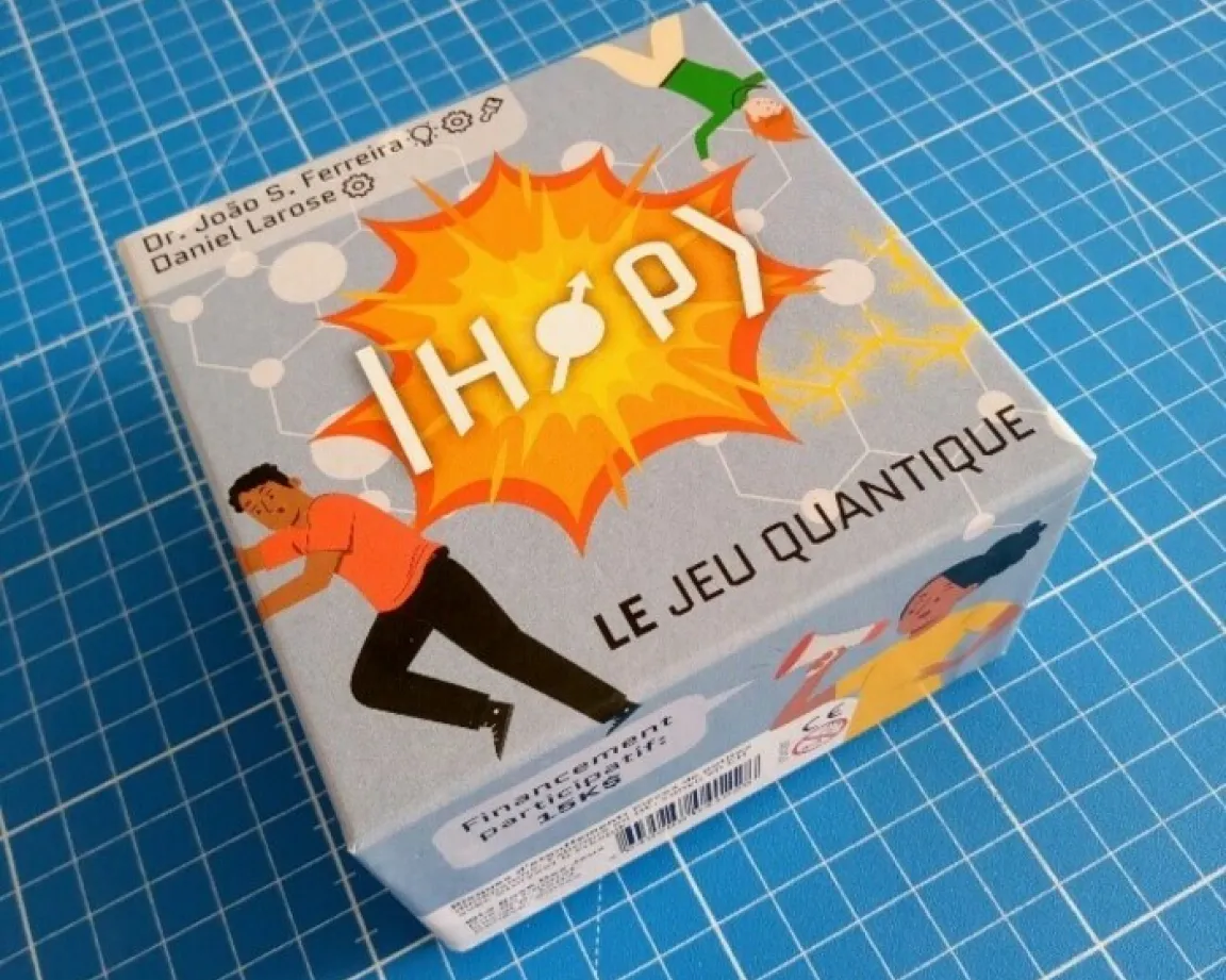 Photo de la boîte du jeu "HOP, le jeu quantique" posée sur une table. Par Dr Joao S. Ferreira et Daniel Larose