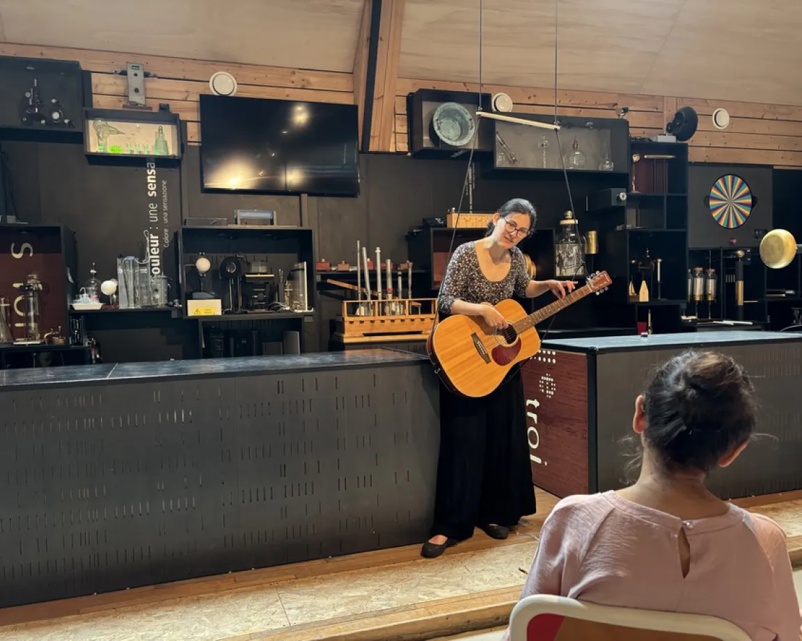 Médiatrice avec une guitare dans une salle de physique des Etincelles