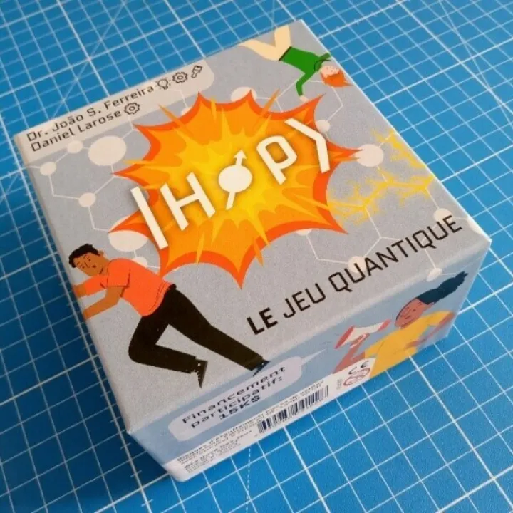 Photo de la boîte du jeu "HOP, le jeu quantique" posée sur une table. Par Dr Joao S. Ferreira et Daniel Larose