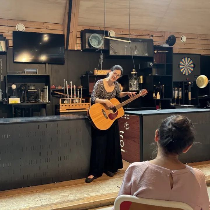 Médiatrice avec une guitare dans une salle de physique des Etincelles